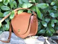 Bolso de cuero marrón con tachuelas, ideal para quienes buscan patrones de bolsos gratis para descargar y crear sus propios accesorios.
