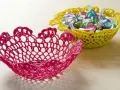 Dos cuencos de ganchillo, uno rosa y otro amarillo lleno de caramelos. Aprende como dar rigidez a una tela para crear estas piezas decorativas.