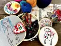Un conjunto de aros de bordado con diseños coloridos y un estilo de bordado creativo. Hay un retrato de mujer, un corazón, un caballo y otros motivos.