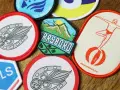 Variedad de parches para ropa, con diseños de herraduras, montañas y un clavadista. Ideas para como hacer parches para ropa.