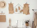 Patrones de papel marrón colgados en la pared, como se llama el papel para hacer patrones. Máquina de coser y ropa en un perchero.