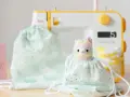 Un patrón de mochila de tela con un adorable diseño de gatitos y un peluche de llama arcoíris, listo para ser cosido.
