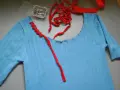 Jersey azul de punto con cuello cortado y tijeras.