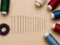 Hilos de colores y agujas de coser, perfectos para tu próximo proyecto de blog de costura.