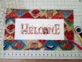 Un bordado de "Welcome" con un pavo, listo para enmarcar telas bordadas con un diseño otoñal.