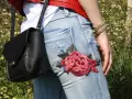 Detalle de unos pantalones vaqueros con un llamativo bordado de rosa roja, perfectos para tunear tus vaqueros y darle un toque único.