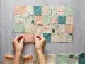 Manos uniendo retazos de tela con diseños de árboles y flechas, creando un patrón de patchwork.