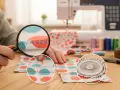 Detalle de puntadas de zigzag en tela con lunares, ideal para aprender como coser tul a mano. Máquina de coser y hilos de colores al fondo.