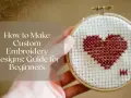 Un corazón rojo en punto de cruz sobre tela blanca, parte de un tutorial de **diseño bordado** para principiantes.
