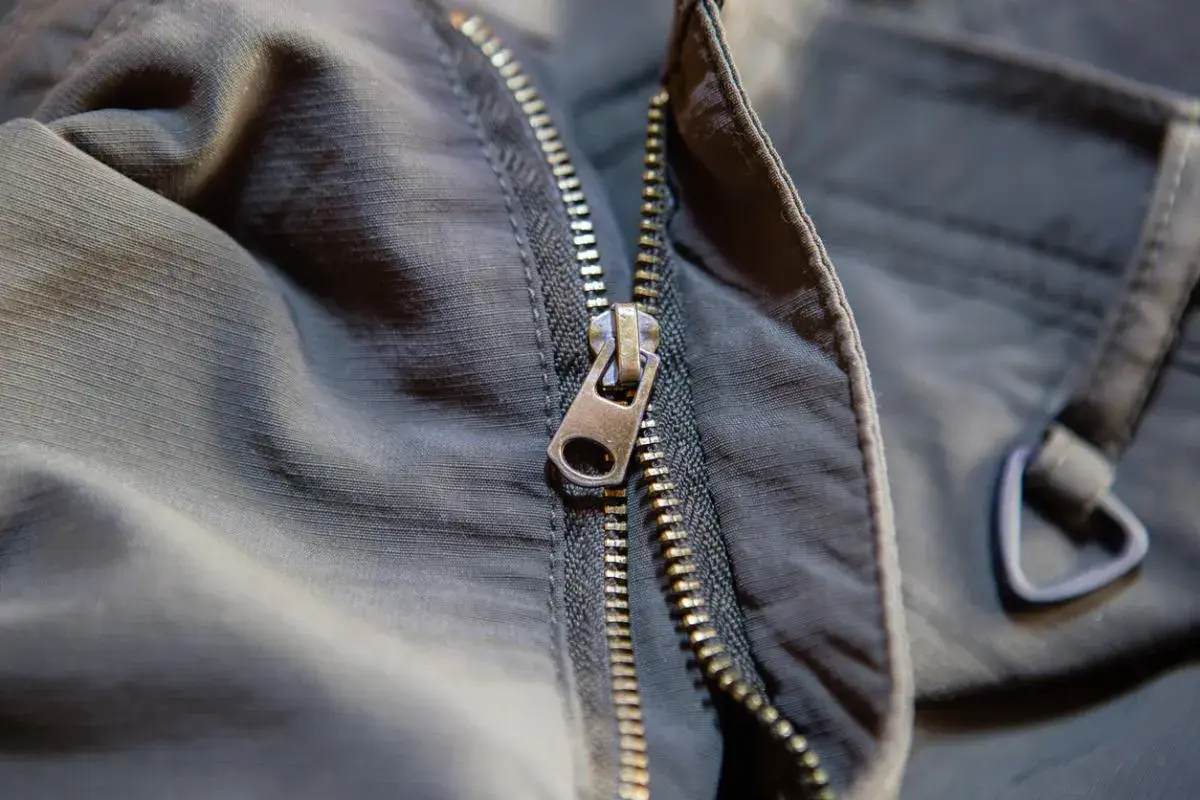 Detalle de cremallera de chaqueta oscura, útil para saber como arreglar una cremallera atascada o rota.
