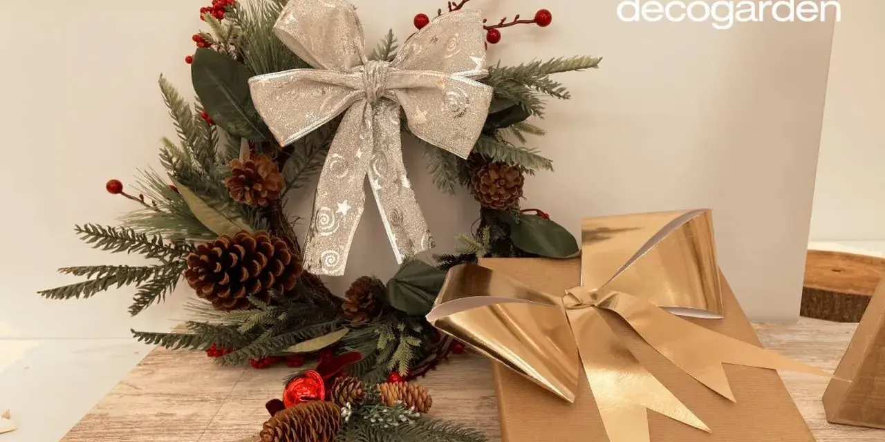 Corona navideña con lazo plateado y regalos con lazo dorado. Aprende como hacer un lazo con cinta ancha para tus decoraciones.
