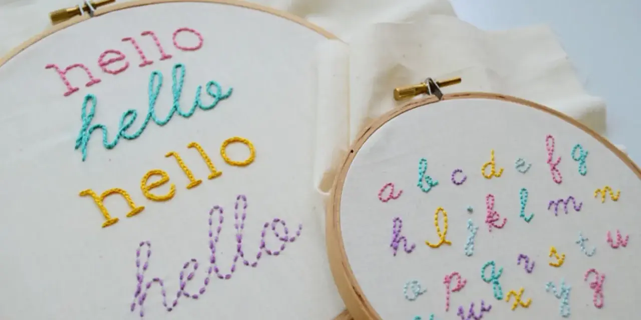 Bastidores de bordado con la palabra "hello" en varios colores y un abecedario completo. Ideales para practicar letras para bordar nombres.
