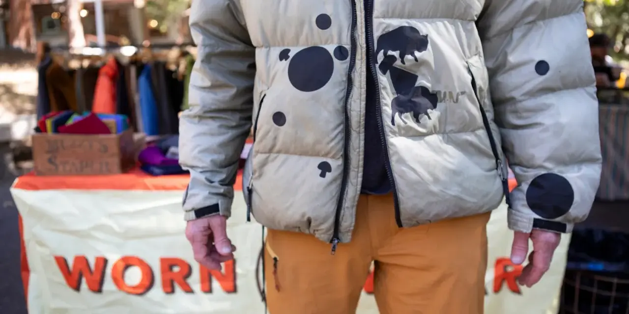 Hombre con chaqueta acolchada beige con manchas negras y bisontes. Aprende como arreglar una chaqueta acolchada para que dure.