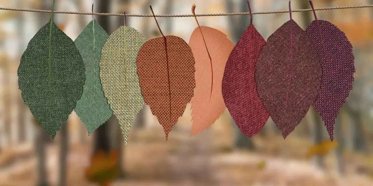 Hojas de tela de otoño colgadas en una cuerda. Ideas de cosas para hacer con telas, como manualidades o decoración.
