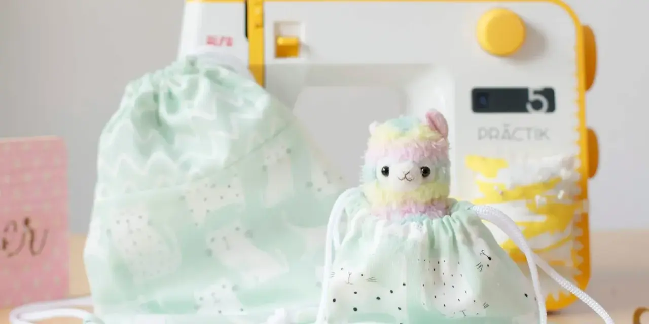 Un patrón de mochila de tela con un adorable diseño de gatitos y un peluche de llama arcoíris, listo para ser cosido.