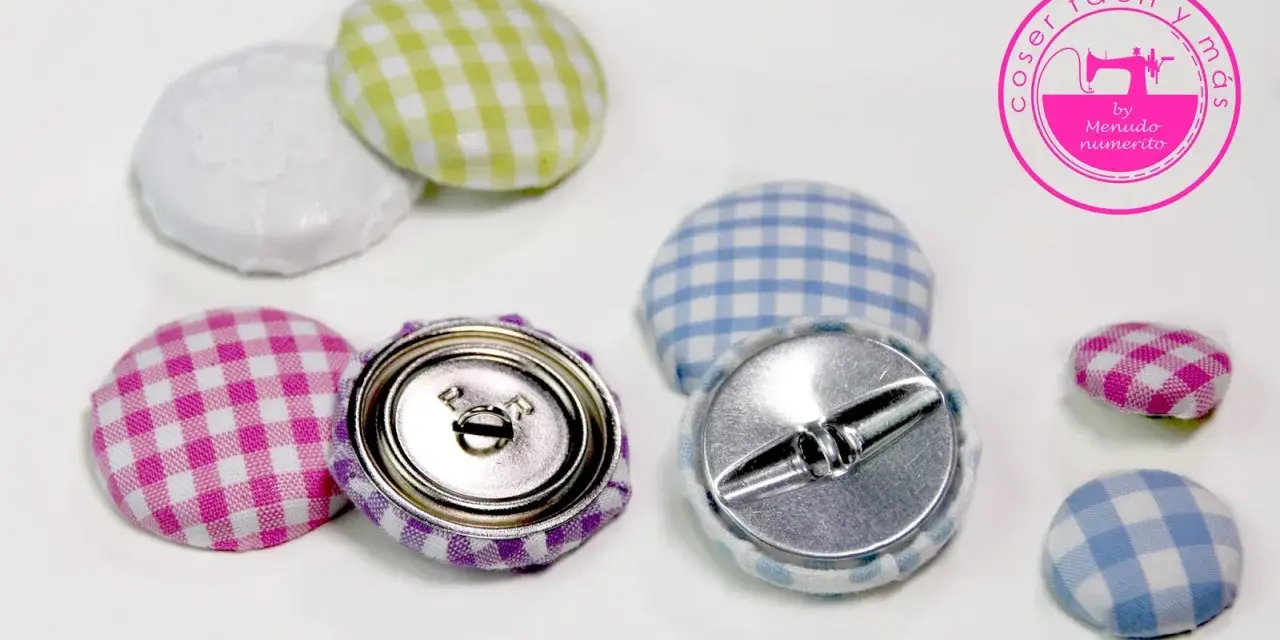 Botones forrados con tela de cuadros vichy en rosa, morado, verde y azul. Se ven los cierres metálicos.
