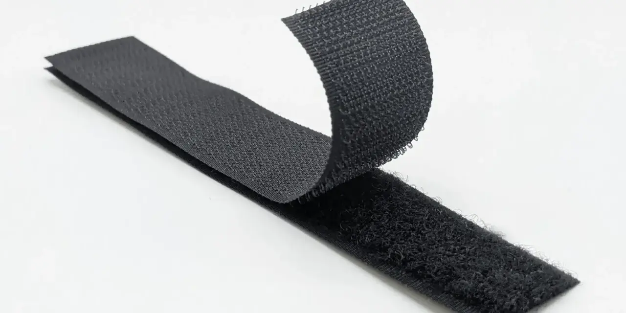 Cintas de velcro negro separándose. Inspirado en la naturaleza, George de Mestral es quién inventó el velcro.