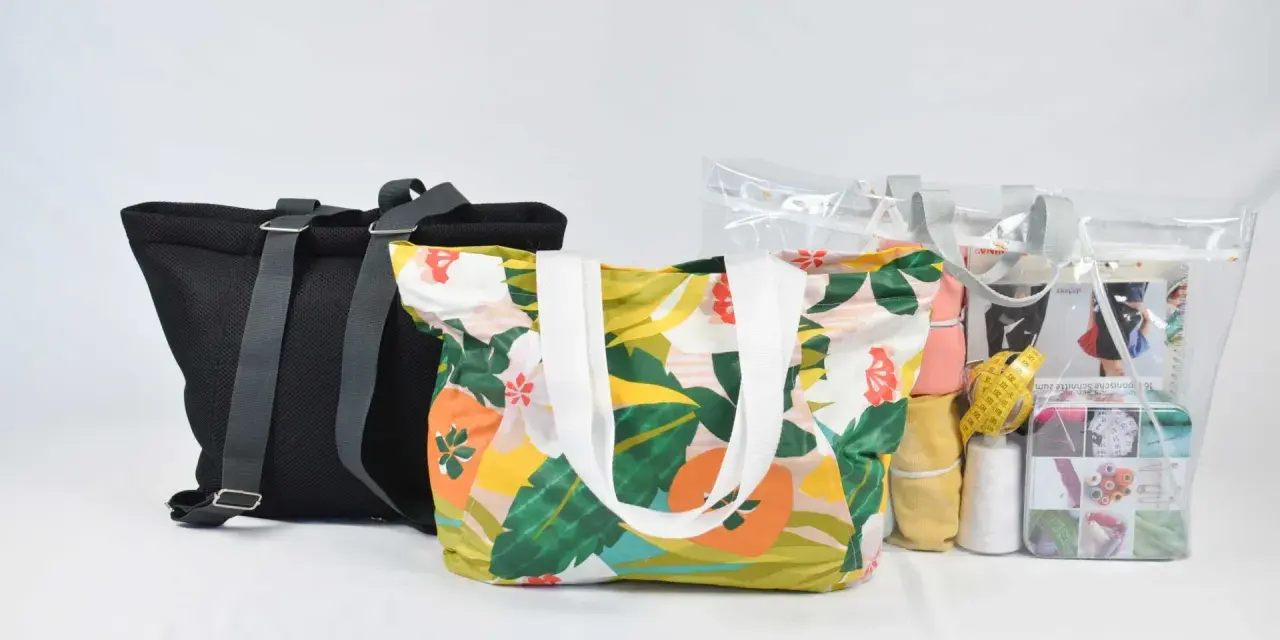 Bolsas de tela con estampado floral y una bolsa transparente con materiales de costura, incluyendo un patrón.