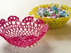 Dos cuencos de ganchillo, uno rosa y otro amarillo lleno de caramelos. Aprende como dar rigidez a una tela para crear estas piezas decorativas.
