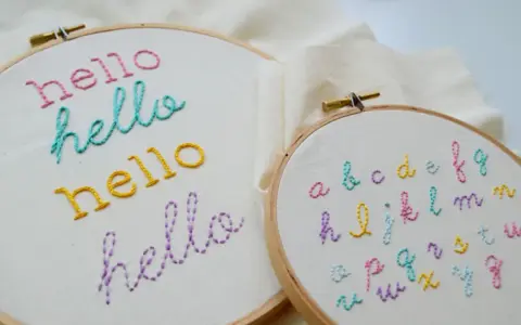 Bastidores de bordado con la palabra "hello" en varios colores y un abecedario completo. Ideales para practicar letras para bordar nombres.