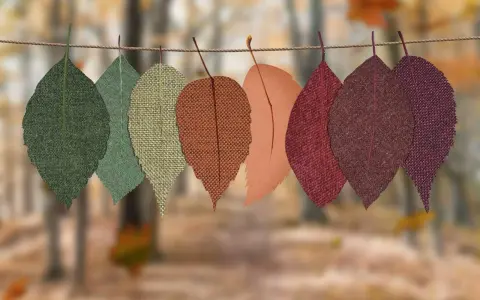 Hojas de tela de otoño colgadas en una cuerda. Ideas de cosas para hacer con telas, como manualidades o decoración.