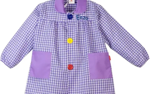 Batas con nombre bordado "Enzo", a cuadros lilas y blancos, con bolsillos y botones de colores.