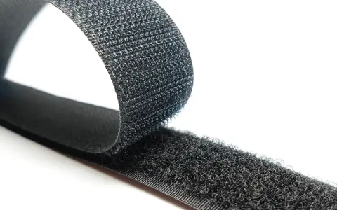Cinta negra con dos caras: una suave y otra con pequeños ganchos. Así es que es velcro, ideal para unir objetos.