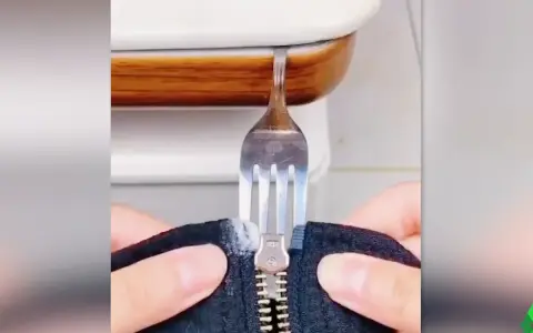 Demostración de como arreglar una cremallera con un tenedor. Un tenedor se usa para manipular una cremallera atascada.