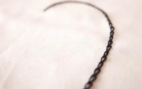Un delicado corazón bordado con punto cadeneta sobre tela clara.