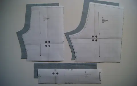 Patrón de costura para un pantalón corto de niño, con piezas de tela azul claro superpuestas.