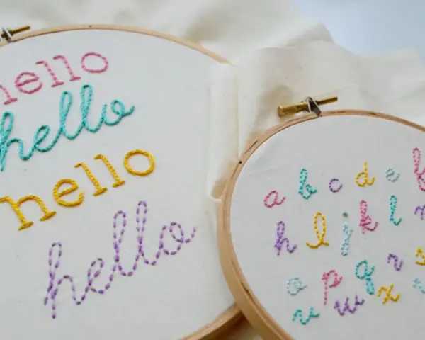 Bastidores de bordado con la palabra "hello" en varios colores y un abecedario completo. Ideales para practicar letras para bordar nombres.