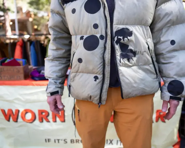 Hombre con chaqueta acolchada beige con manchas negras y bisontes. Aprende como arreglar una chaqueta acolchada para que dure.