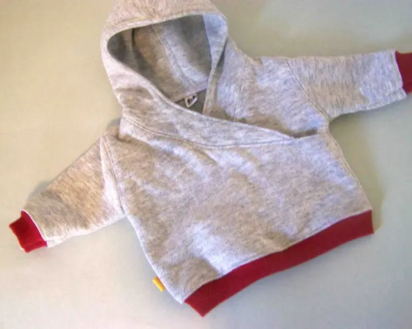 Saco de bebé gris con capucha y puños rojos. Un patrón de saco de bebé con capucha listo para coser.