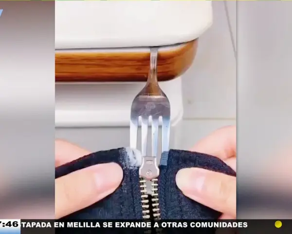 Demostración de como arreglar una cremallera con un tenedor. Un tenedor se usa para manipular una cremallera atascada.