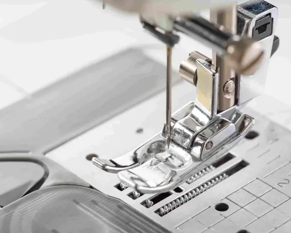 Primer plano del prensatelas de una máquina de coser, listo para guiar la tela con precisión.