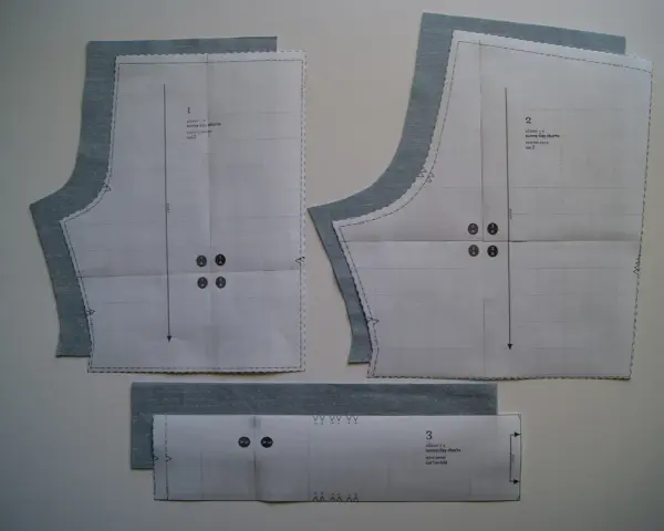 Patrón de costura para un pantalón corto de niño, con piezas de tela azul claro superpuestas.