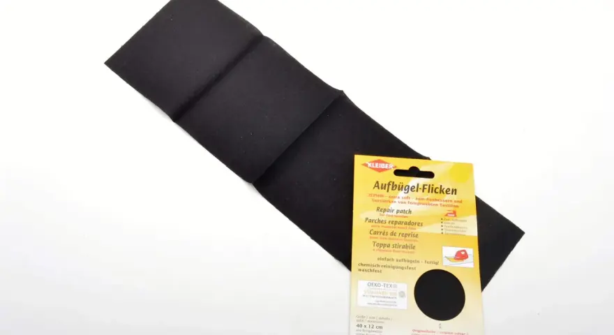Parche negro para reparar textiles, ideal para saber como pegar un parche con plancha. Fácil de usar y duradero.