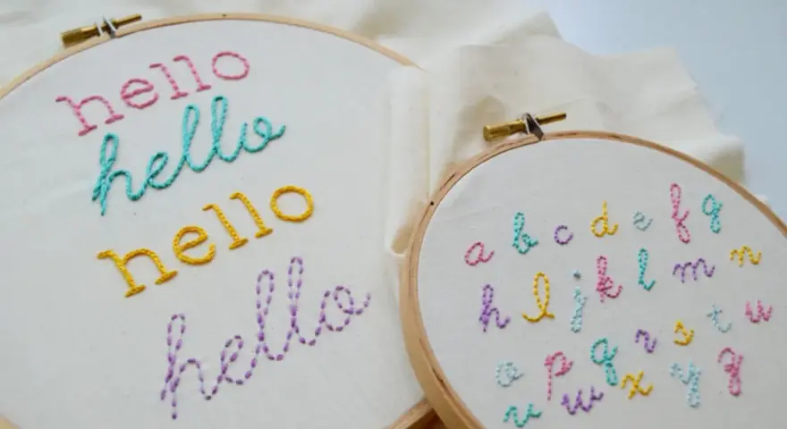 Bastidores de bordado con la palabra "hello" en varios colores y un abecedario completo. Ideales para practicar letras para bordar nombres.