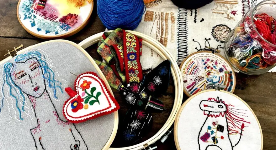 Un conjunto de aros de bordado con diseños coloridos y un estilo de bordado creativo. Hay un retrato de mujer, un corazón, un caballo y otros motivos.