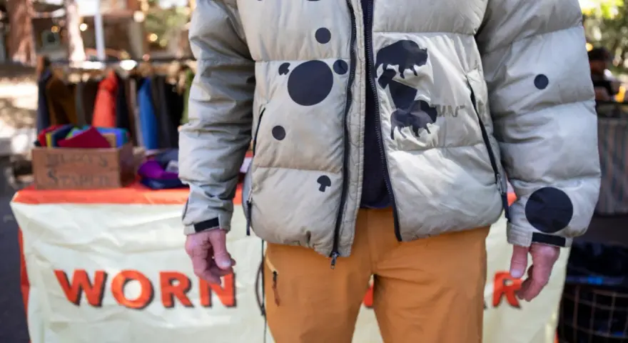 Hombre con chaqueta acolchada beige con manchas negras y bisontes. Aprende como arreglar una chaqueta acolchada para que dure.