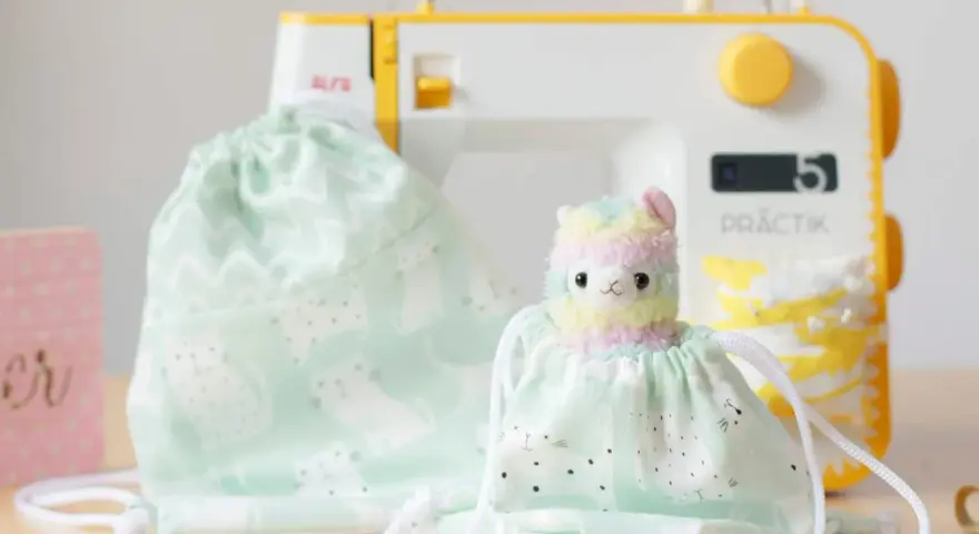 Un patrón de mochila de tela con un adorable diseño de gatitos y un peluche de llama arcoíris, listo para ser cosido.