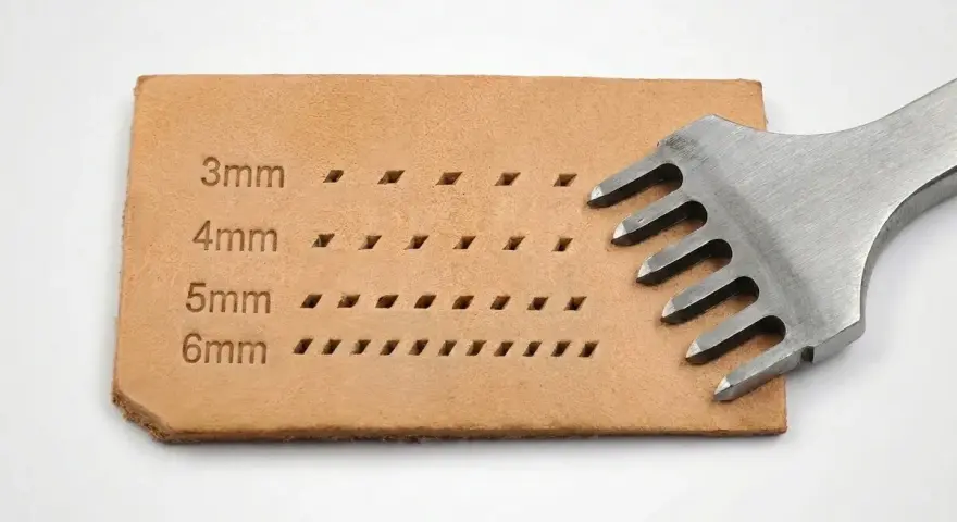 Un punzón de cuero con dientes metálicos crea filas de agujeros en una tira de cuero, mostrando diferentes tamaños de puntadas.