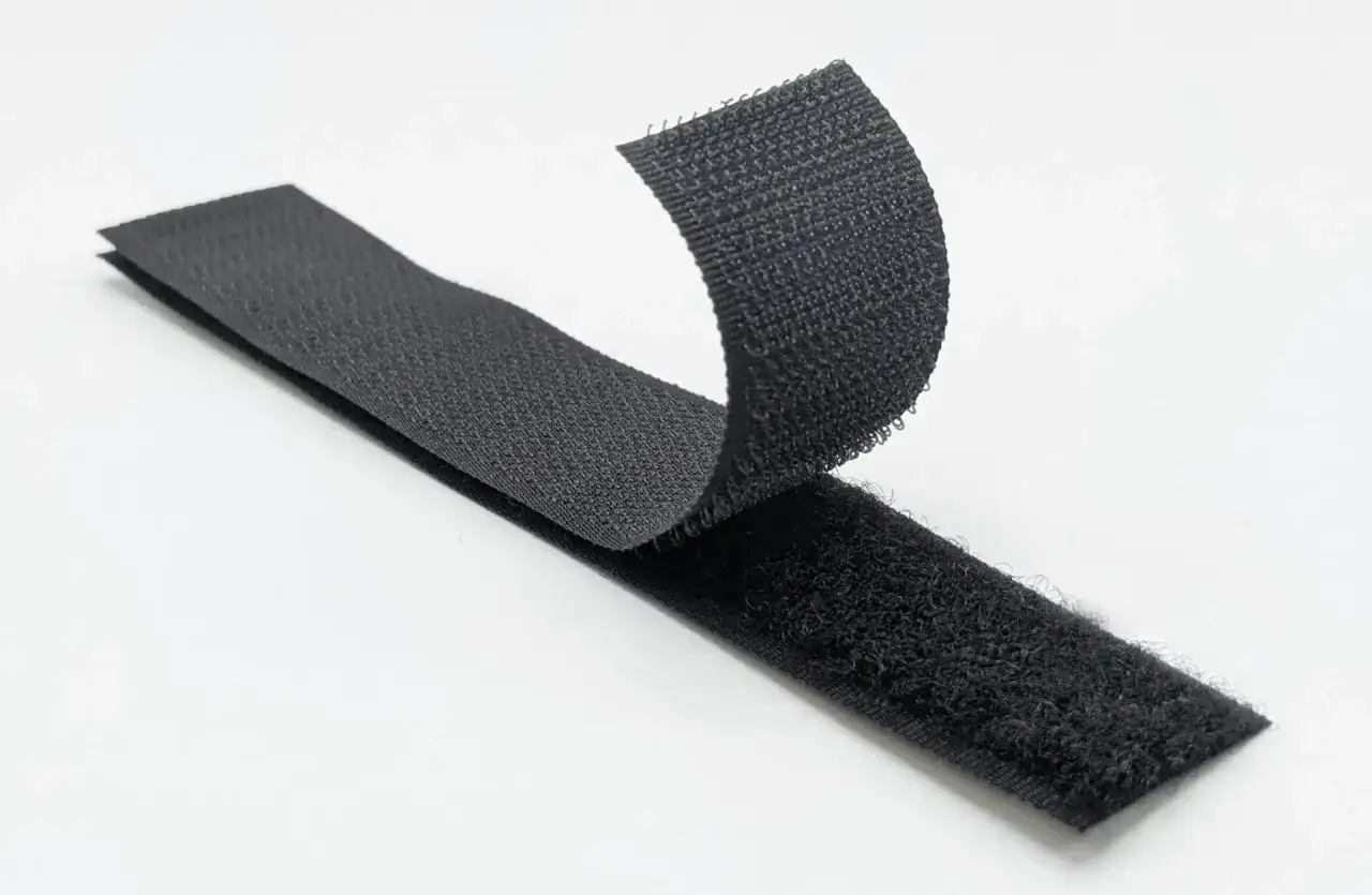 Cintas de velcro negro separ&aacute;ndose. Inspirado en la naturaleza, George de Mestral es qui&eacute;n invent&oacute; el velcro.