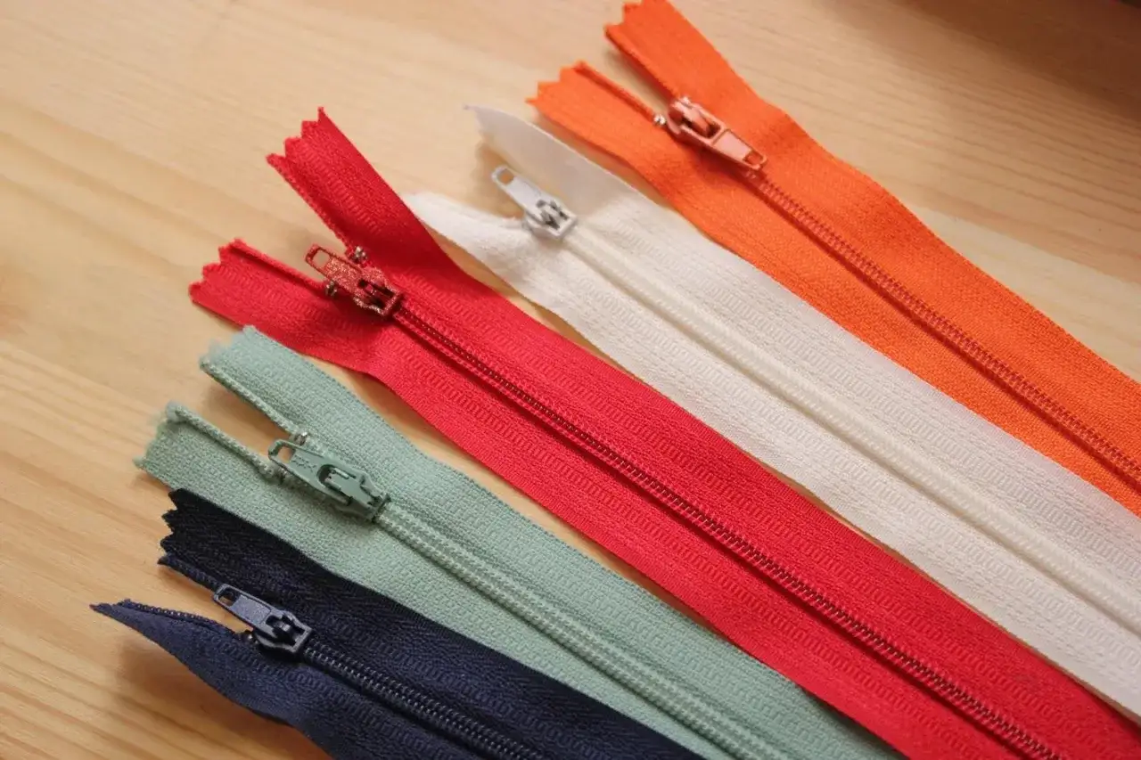 Variedad de cremalleras de colores: azul marino, verde menta, rojo, blanco y naranja. Listas para poner cremallera a cualquier proyecto.