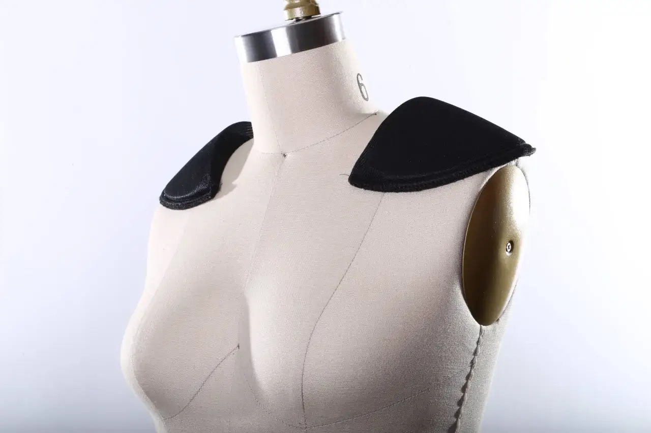 Maniquí con dos tipos de hombreras negras cosidas en los hombros, mostrando diferentes estilos para realzar la silueta.