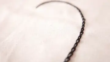 Un delicado corazón bordado con punto cadeneta sobre tela clara.
